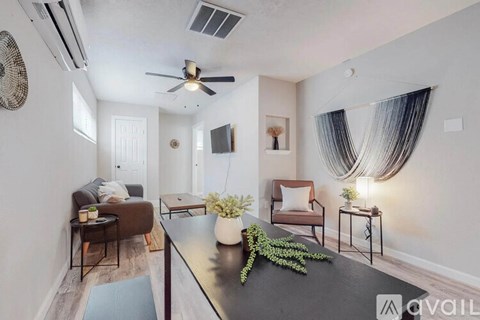 A living room with a black table and a ceiling fan.