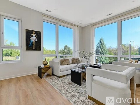 A living room with a white couch and a painting on the wall.