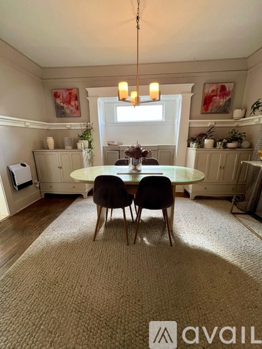 A dining room with a round table and chairs.
