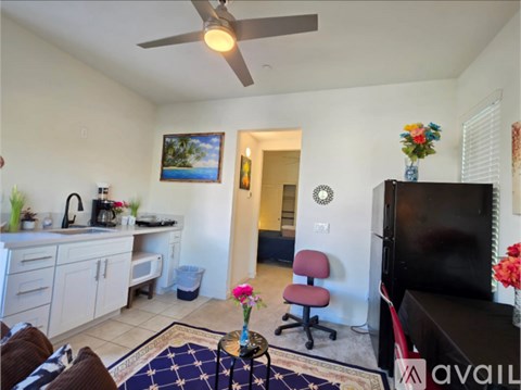 A living room with a ceiling fan and a painting on the wall.