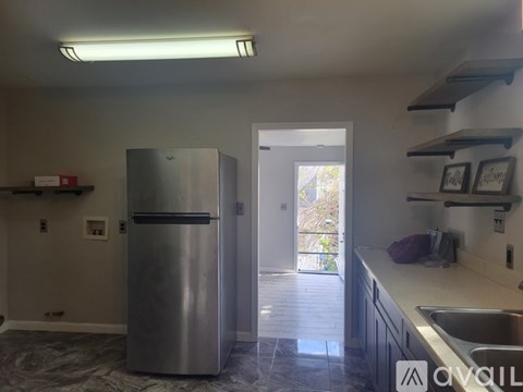 A kitchen with a stainless steel refrigerator and a sink.