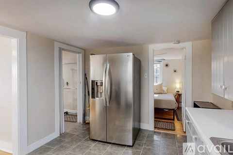 A stainless steel refrigerator is in the middle of a kitchen.