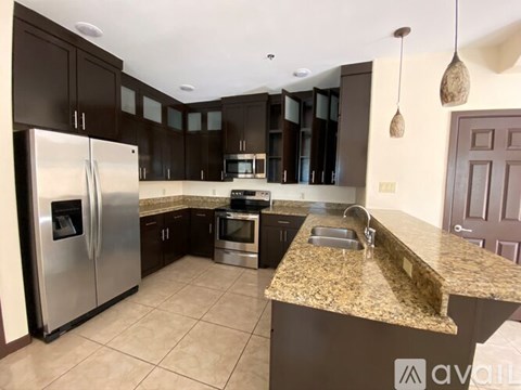 A kitchen with a granite countertop and stainless steel appliances.
