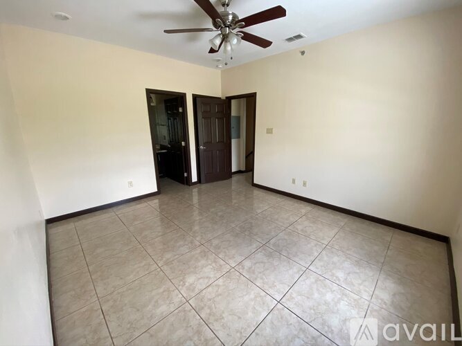 A room with a ceiling fan and tiled floor.