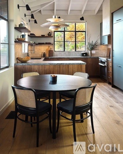 A kitchen with a table and chairs in the foreground and a refrigerator in the background.