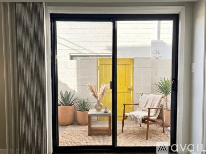 A room with a yellow door and a chair with a blanket on it.