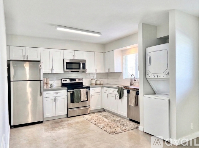A kitchen with white cabinets and appliances.