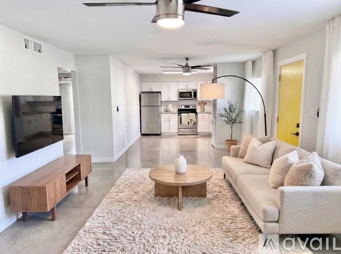 A modern living room with a flat screen TV, a sofa, and a coffee table.