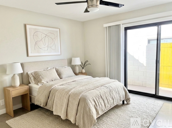 A bedroom with a bed, nightstand, and a ceiling fan.