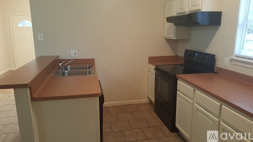 A kitchen with a black oven and white cabinets.