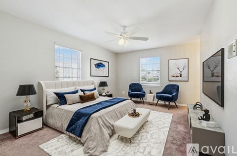 A bedroom with a large bed and a ceiling fan.