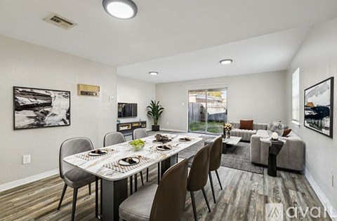 A dining room with a long table and chairs.