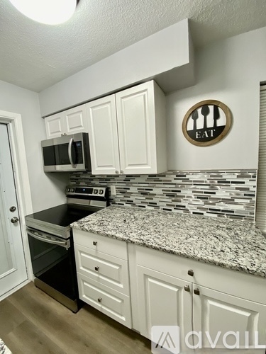 A kitchen with a granite countertop and a sign that says "EAT".