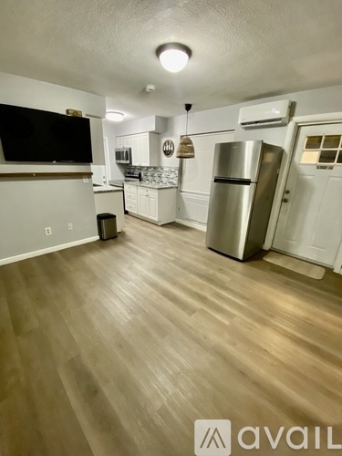 A kitchen with wooden floors and a refrigerator.