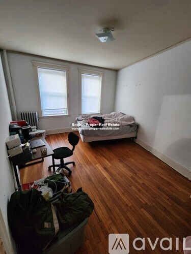 A room with a bed, desk, and chair.