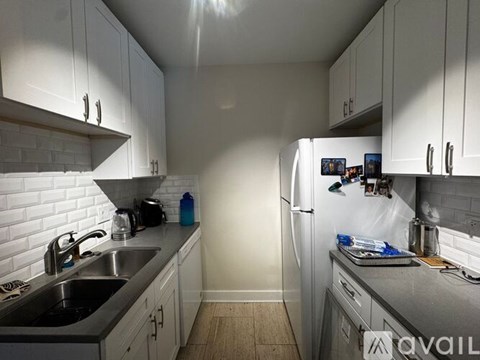 A kitchen with white appliances and wooden cabinets.