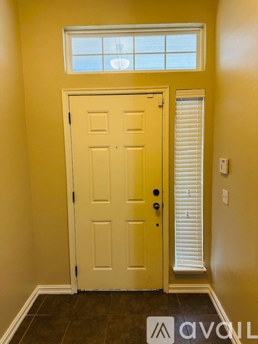 A white door with a black handle is in a room with yellow walls.