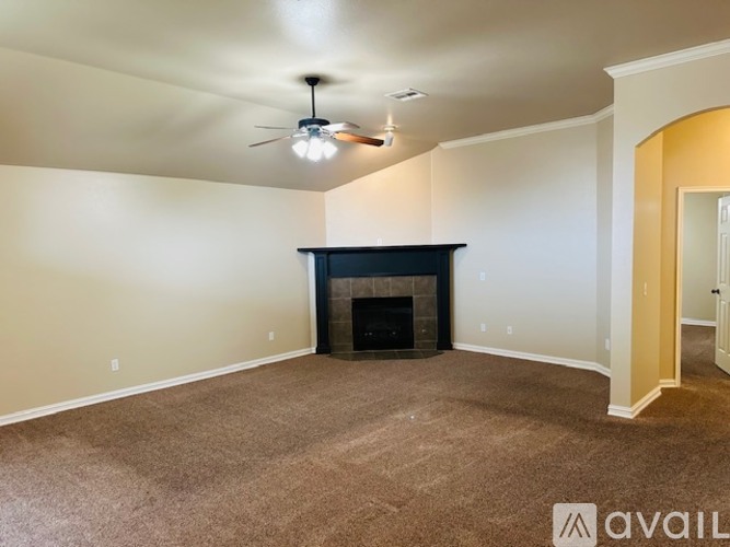 A living room with a fireplace and a ceiling fan.
