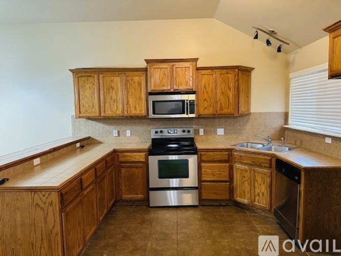 A kitchen with wooden cabinets and a stainless steel oven.