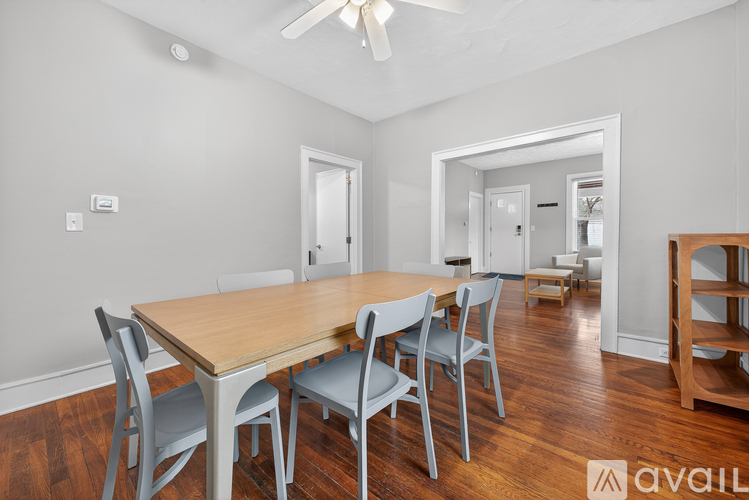 A dining room with a wooden table and chairs.