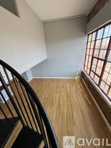 A wooden staircase leads to a bright room with a window.