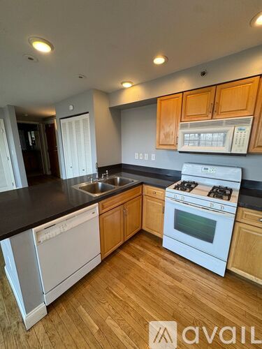 A kitchen with wooden cabinets and white appliances.