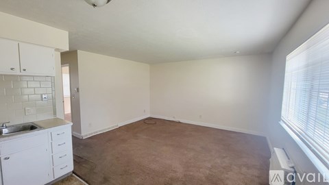 A room with a kitchenette and a window.