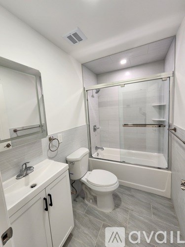 A bathroom with a toilet, sink, and shower.