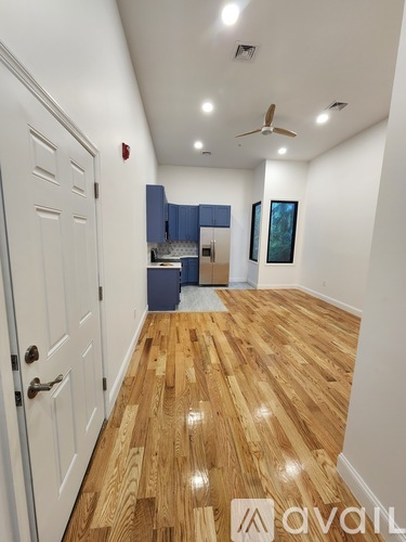 A hallway with wooden floors and a white door.