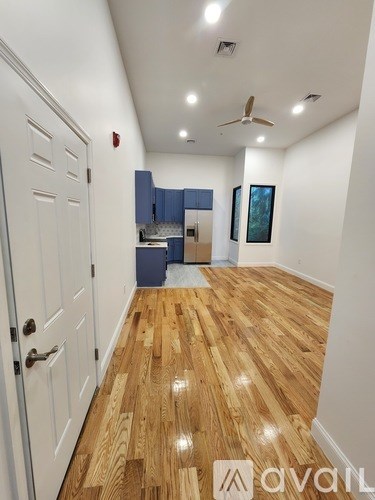 A hallway with wooden floors and a white door.