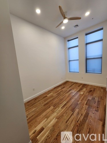 A room with wooden flooring and a ceiling fan.