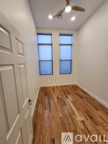 A room with wooden floors and a ceiling fan.
