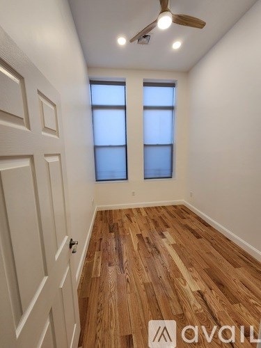 A room with wooden floors and a ceiling fan.
