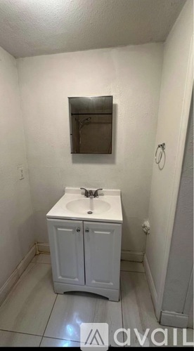 A small white bathroom with a sink and cabinet.