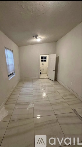 A room with a tiled floor and a door in the background.