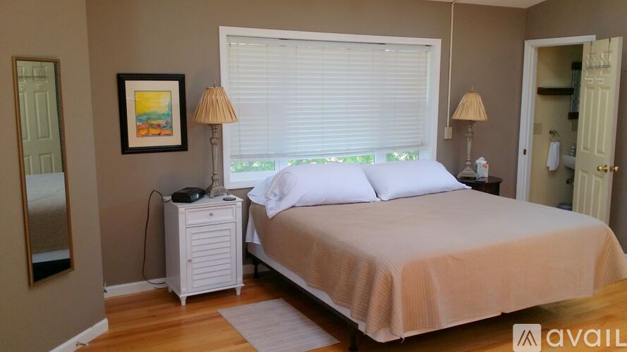 A bedroom with a bed, nightstand, and lamp.