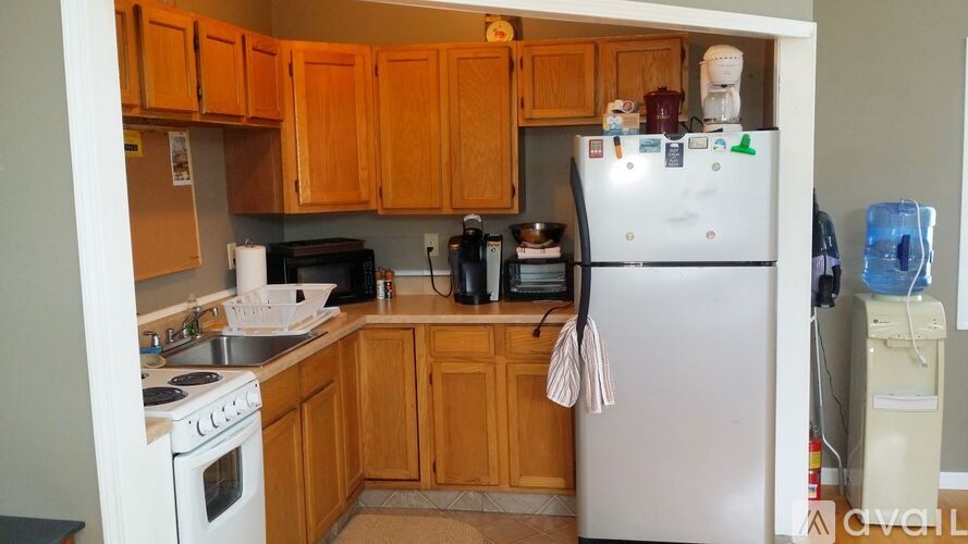 A kitchen with wooden cabinets and a white refrigerator.