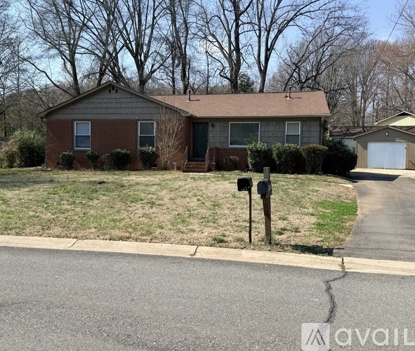 A house with a brown roof and a driveway in front.