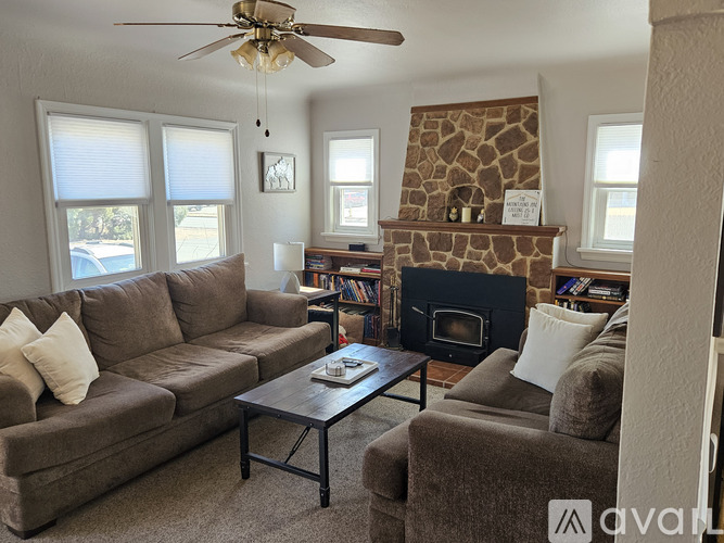 A living room with a couch, a coffee table, and a fireplace.