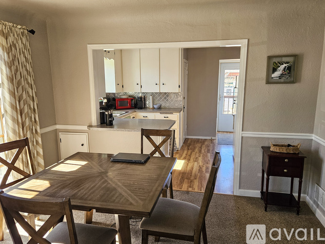 A dining room with a wooden table and chairs.