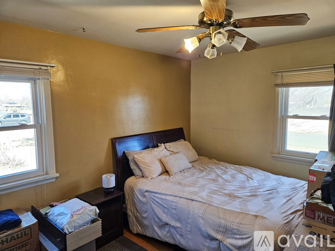 A bedroom with a bed, nightstand, and window.