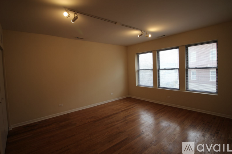 Empty room with wooden floors and windows.