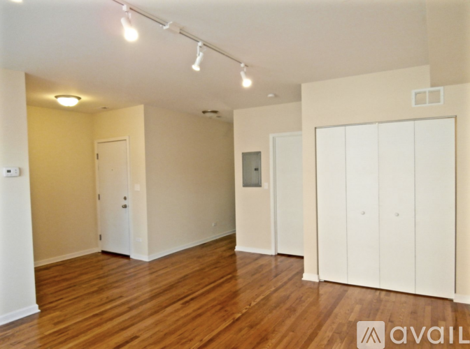 A spacious room with wooden floors and white walls.