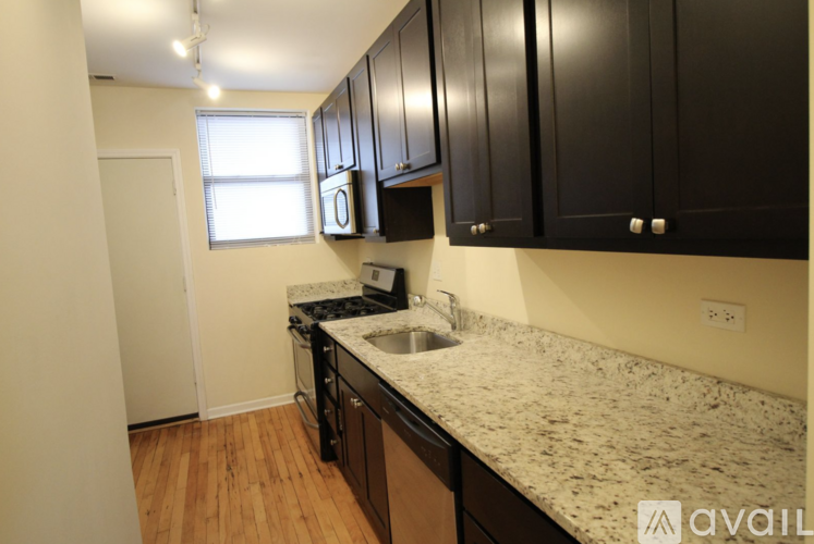 A kitchen with black cabinets and a granite countertop.