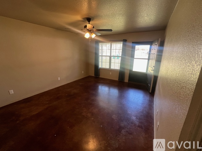 A room with a ceiling fan and a window with blinds.
