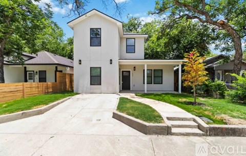 A modern two-story house with a white exterior and a large front yard.