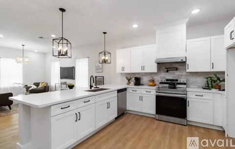 A modern kitchen with white cabinets and stainless steel appliances.