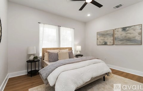 A bedroom with a large bed and a ceiling fan.