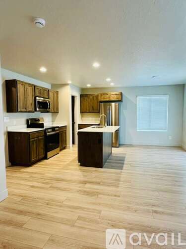 A kitchen with wooden floors and cabinets.