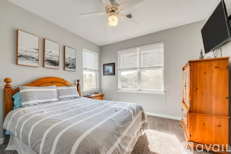 A bedroom with a large bed and a television on the wall.